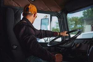 Trucker in His 40s Inside Vintage Aged Semi Truck Tractor Cabin photo