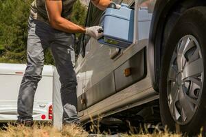 Men Removing Toilet Cassette From His Camper Van RV photo