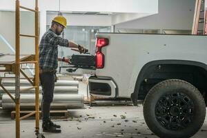 construcción trabajador cargando herramientas dentro el recoger coche foto