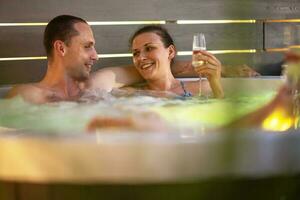 Pareja teniendo romántico hora en su jardín caliente tina spa foto