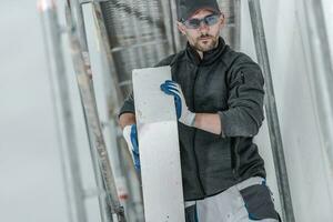 Caucasian Construction Worker Installing Insulation Material On Outside Walls Of House. photo