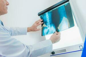 médico mirando a paciente radiografía. foto