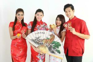 sur este asiático joven malayo chino indio hombre mujer vistiendo tradicional chino cheongsam vestir en blanco antecedentes tienda intercambiar regalo naranja saludos compartir racial unidad armonía mano ventilador foto