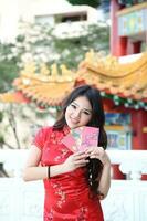 joven sur este asiático chino hombre mujer tradicional disfraz chino nuevo año saludo al aire libre a templo foto