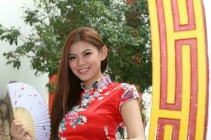 Young south east asian Chinese man woman traditional costume Chinese new year greeting outdoors at temple photo