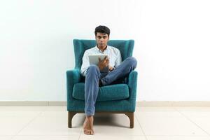 A young south east Asian sit pose look think work study emotion feelings on a blue single sofa. He is adhd and autistic photo