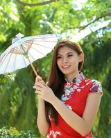 Young south east asian Chinese man woman traditional costume Chinese new year greeting outdoors at temple photo