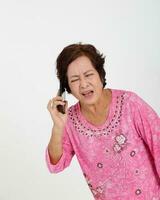 Elderly asian Chinese female on white background talking on phone can not hear face expression photo