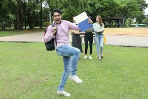 joven asiático malayo chino hombre mujer al aire libre parque libro archivo carpeta ordenador portátil computadora teléfono sentar estar estudiar mezclarse foto