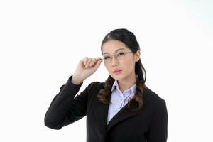 Southeast Asian young office business woman wearing suit holding eye spectacles look at camera on white studio background photo