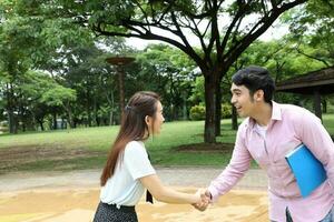 young asian malay chinese man woman outdoor park walk stand study talk discuss laptop file book backpack pose meet handshake photo