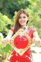 Young south east asian Chinese man woman traditional costume Chinese new year greeting outdoors at temple photo