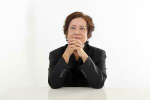 Elderly asian Chinese female on white background wearing black suit thinking hand finger locked photo