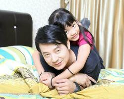 South East Asian young father mother daughter  parent girl child activity indoor photo