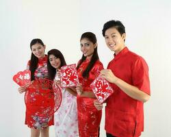 sur este asiático joven malayo chino indio hombre mujer vistiendo tradicional chino cheongsam vestir en blanco antecedentes tienda intercambiar regalo naranja saludos compartir racial unidad armonía mano ventilador foto