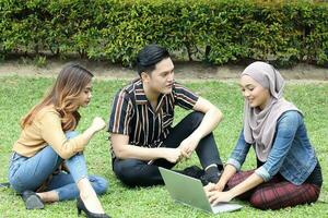 Young Asian different ethnic malay chinse  man woman activity lifestyle student educating job business sit on grass discuss photo