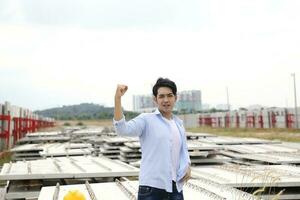 Asian man malay worker engineer management at construction site hard safety hat helmet look forward confident fist in air photo