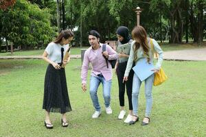 joven asiático malayo chino hombre mujer al aire libre parque libro archivo carpeta ordenador portátil computadora teléfono sentar estar estudiar mezclarse foto