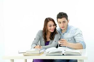 yong sur este asiático medio oriental caucásico juventud hombre mujer en casual vestir sentar a mesa libro cuaderno bolígrafo hablar estudiar pensar rad en blanco antecedentes foto