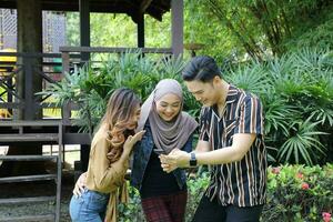 Young Asian Malay man woman outdoor green park walk talk discuss mingle photo