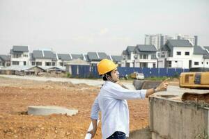 South east Asian construction worker engineer management at construction site hard safety hat helmet photo