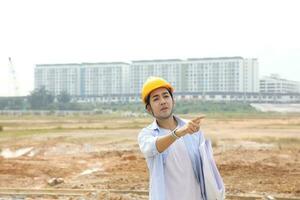 South east Asian construction worker engineer management at construction site hard safety hat helmet photo