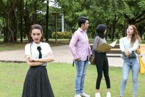 joven asiático malayo chino hombre mujer al aire libre parque caminar estar estudiar hablar discutir punto ordenador portátil archivo libro mochila hembra Mira adelante foto