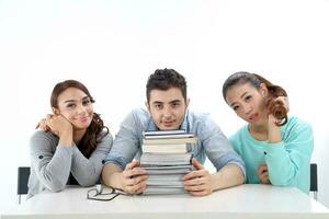 Yong south east Asian middle eastern Caucasian youth man woman in casual dress sit at table stack of book think rest tired look at camera on white background photo