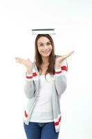 Yong Asian youth girl in casual dress balancing book on head look at camera hand in air expression smile happy funny face on white background photo