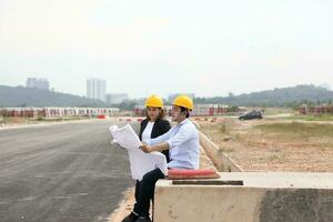 South east Asian construction worker engineer management at construction site hard safety hat helmet photo