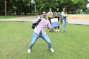 joven asiático malayo chino hombre mujer al aire libre parque libro archivo carpeta ordenador portátil computadora teléfono sentar estar estudiar mezclarse foto