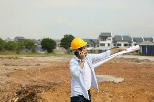 South east Asian construction worker engineer management at construction site hard safety hat helmet photo