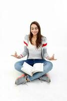 Yong Asian youth girl in casual dress sit on floor book on lap hand yoga expression peace relaxed on white background photo