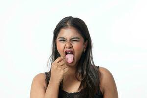 joven atractivo asiático indio mujer actitud cara cuerpo expresión modo emoción en blanco antecedentes siembra dedo en lengua foto