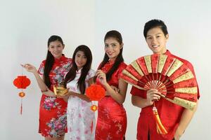 South East Asian young Malay Chinese Indian man woman wearing traditional chinse cheongsam dress on white background shop exchange gift orange greetings share racial unity harmony hand fan photo