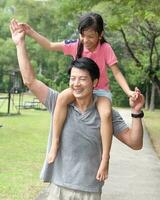 South East Asian young father mother daughter son parent boy girl child activity outdoors park photo