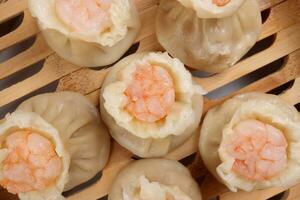 Prawn shrimp shaomai dim sum dumpling in bamboo steamer on white background photo