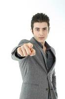 Middle eastern Caucasian young office business man wearing suit point finger at camera on white studio background focus on face photo