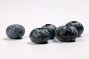 Fresh ripe deep purple Blueberry on white background macro closeup photo