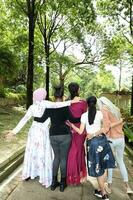 grupo de mujer malayo chino indio asiático al aire libre verde parque caminar mano en hombro juntos unidad foto