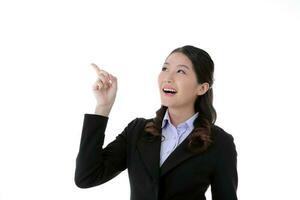 Southeast Asian young office business woman wearing suit point up happy smile expression on white studio background photo