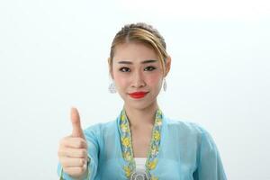 Asian woman traditional blue orange kebaya sharong on white  background thumbs up photo