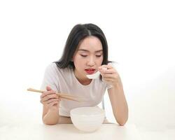 Beautiful young south east Asian woman holding chinese empty chopstick soup spoon bowl utensil pretend acting posing see eat taste feed offer satisfaction yummy white background happy photo