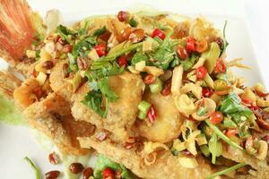 Deep fried freshwater red whole tilapia fish sliced fillet with Thai style lemongrass coriander shallot sauce photo