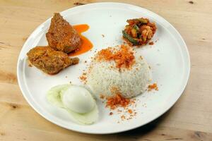 Nasi Lemak Rice cooked with coconut milk floss with curry chicken sambal vegetable boiled egg cucumber slice photo