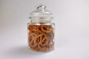 Pretzel cracker in a glass jar on white background photo