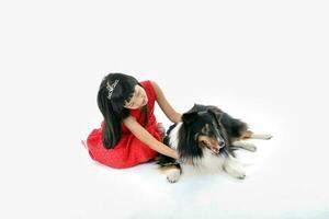 Southeast Asian young girl child with pet dog playing petting happy photo