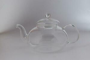 Empty transparent glass see through teapot kettle on white background photo