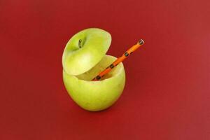 Healthy Green Cut Apple recyclable paper straw juice drink idea concept on red background photo