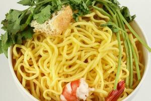 Fresh yellow egg noodle prawn tofu coriander leaf in bowl on whit background photo